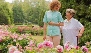Two people smiling walking in a garden